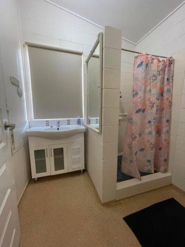 a small bathroom with a shower and a sink at Keppel Cottage - 7 Limpus Avenue Keppel Sands in Keppel Sands