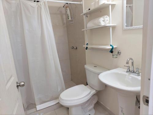 La salle de bains blanche est pourvue de toilettes et d'un lavabo. dans l'établissement Departamento 22 centrico,cerca de los destinos clave, CAS, Consulado, Centro de Gobierno y Galerías Mall, à Hermosillo
