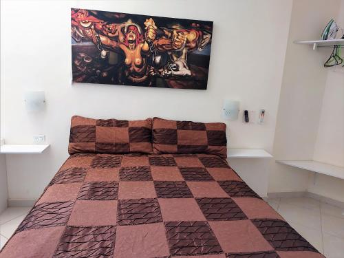 - une chambre avec un lit et une couverture en damier dans l'établissement Departamento 22 centrico,cerca de los destinos clave, CAS, Consulado, Centro de Gobierno y Galerías Mall, à Hermosillo