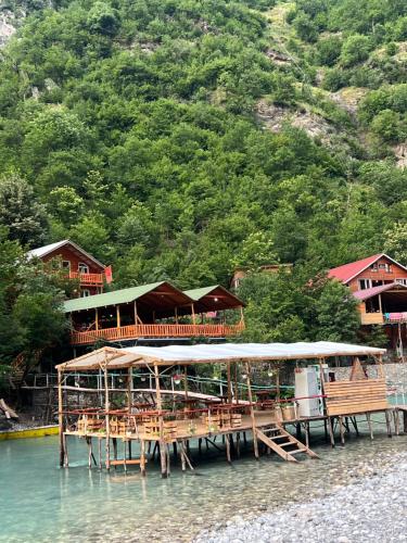 a pier with tables and chairs on the water at Guesthouse Zgiboza in Shkodër