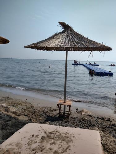 - une chaise sous un parasol sur la plage dans l'établissement Durazzo Vollga 1, à Durrës