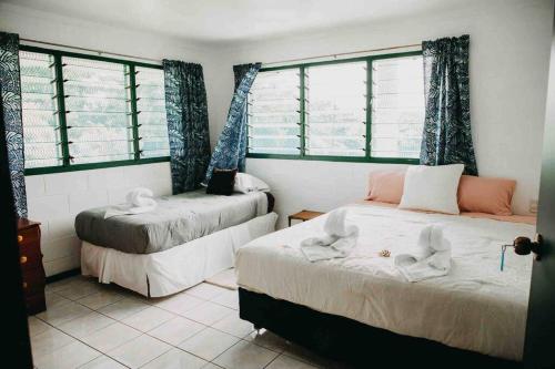 a room with two beds and two windows at Heavenly Home in Apia