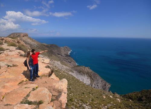 a man and woman standing on the edge of a cliff at Hotel Calachica Las Negras in Las Negras