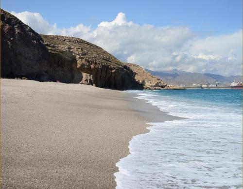 a beach with a rocky shore and the ocean at Hotel Calachica Las Negras in Las Negras