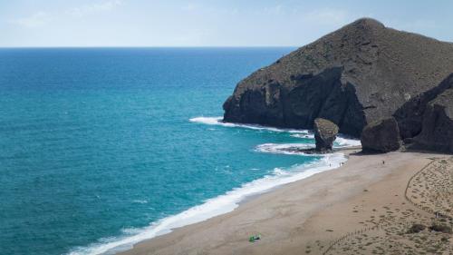 an aerial view of a beach with a large rock formation at Hotel Calachica Las Negras in Las Negras