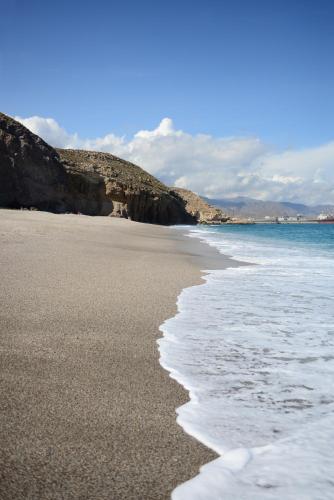 a sandy beach with the ocean in the background at Hotel Calachica Las Negras in Las Negras