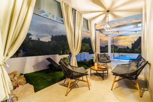 a living room with chairs and a large window at Villa Renesansa in Milna