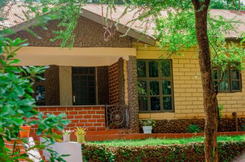 a yellow brick house with a tree in front of it at Hostel Kiliwood in Moshi