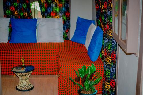 a bedroom with a red bed with blue pillows at Hostel Kiliwood in Moshi