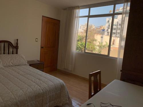 sypialnia z łóżkiem i dużym oknem w obiekcie Habitación con baño propio para 2 personas como máximo w mieście Lima