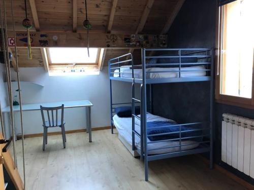 une chambre avec des lits superposés, une table et une chaise dans l'établissement Comme à la maison à la montagne, à Briançon