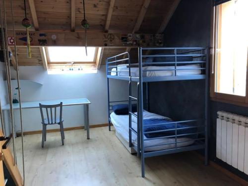 a room with bunk beds and a table and a chair at Comme à la maison à la montagne in Briançon