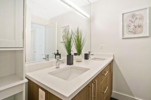 a white bathroom with a sink and a mirror at Luxurious and stylish 2 bedroom 2 bathroom suite in Washington, D.C.