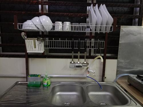 un lavello con utensili da cucina su uno scaffale sopra di esso di Aras G Homestay a Gambang