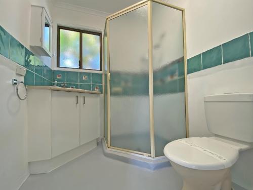 uma casa de banho com um WC e uma cabina de duche em vidro. em BELLES ON BALLOW - POSSUM LODGE em Amity Point