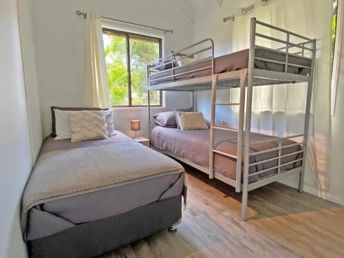 a bedroom with two bunk beds and a bed at BELLES ON BALLOW - POSSUM LODGE in Amity Point