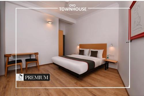 a hotel room with a bed and a desk and a room at Townhouse Singapore Mall in Chinhat
