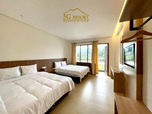 een hotelkamer met 2 bedden en een raam bij 5G Resort Cijeruk in Bogor