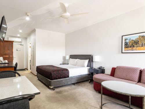 a hotel room with a bed and a couch at Hotel Renmark in Renmark