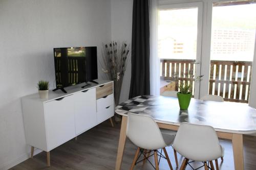 une salle à manger avec une table et une télévision dans l'établissement Résidence Les Chaumettes - TRES BEL APPARTEMENET ENTIEREMENT RENOVE MAE-0124, à Saint-Étienne-en-Dévoluy