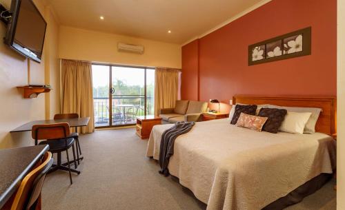 a bedroom with a bed and a desk and a chair at Hotel Renmark in Renmark