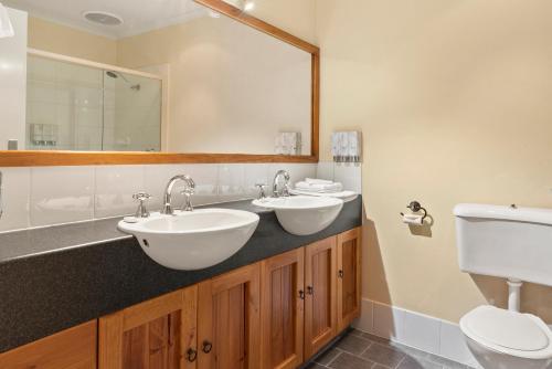 a bathroom with two sinks and a toilet at Hotel Renmark in Renmark