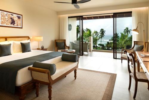 a bedroom with a bed and a view of the ocean at Anantara Peace Haven Tangalle Resort in Tangalle