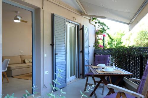 a patio with a table and a door to a yard at Sti Chora Apartments in Lefkada Town