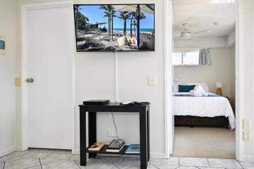 a room with a bed and a table with a picture on the wall at Mooloolaba 2 B/R Getaway - Perfect location ZD5 in Mooloolaba