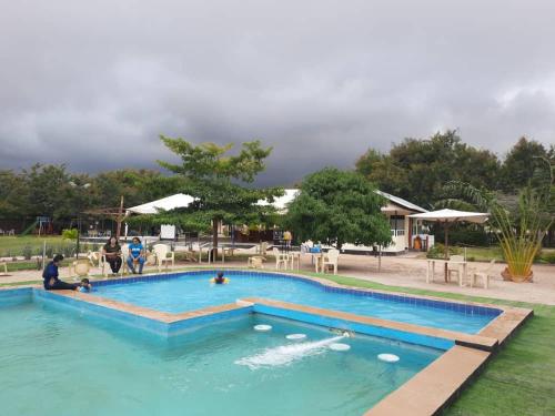 uma grande piscina com pessoas na água em Remarkable 10-Bed Cottages in Bagamoyo em Bunju