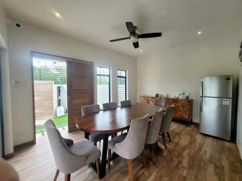 a dining room with a table and chairs and a refrigerator at Lux 7 Pool Villa Mactan in Mactan