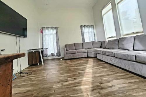 uma sala de estar com um sofá e uma televisão de ecrã plano em Lux 7 Pool Villa Mactan em Mactan