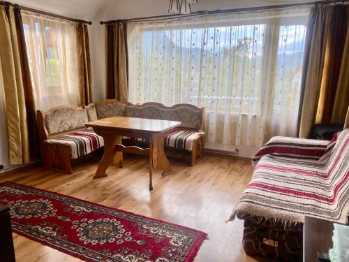 a living room with a table and a couch at Casa De Vacanta Elena in Sinaia