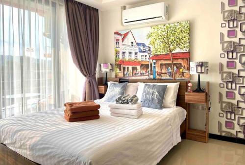a bedroom with a bed with a painting on the wall at NEW one bedroom apartment MBC E in Ban Bo Sai Klang