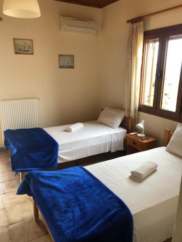 a room with two beds with blue sheets on them at NorthWest Studios in Argostoli