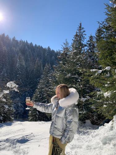 a woman holding a glass of wine in the snow at Терношорська Лада in Snidavka