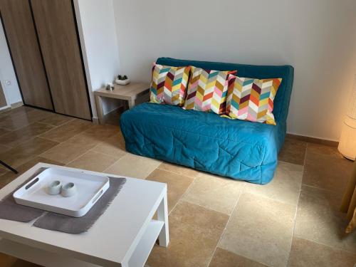 a living room with a blue couch and a coffee table at LA DOUCE in Le Castellet