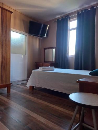 sypialnia z dużym łóżkiem z niebieskimi zasłonami w obiekcie En-suite Rooms in shared appartment w mieście Quatre Bornes