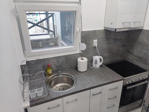 a small kitchen with a sink and a window at Eleven And A Half apartment Superior in Nea Fokea