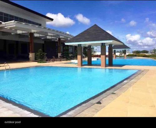 a large blue swimming pool with a gazebo at Condo Unit at Cool Suites SMDC Wind Tagaytay in Tagaytay