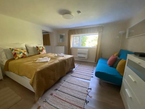 a bedroom with a bed and a blue couch at Lilakő Apartman in Mátraszentimre