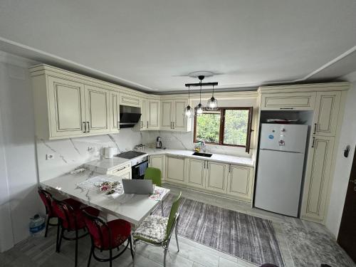 uma cozinha com armários brancos e uma mesa com cadeiras em Yomra / Trabzon em Yomra