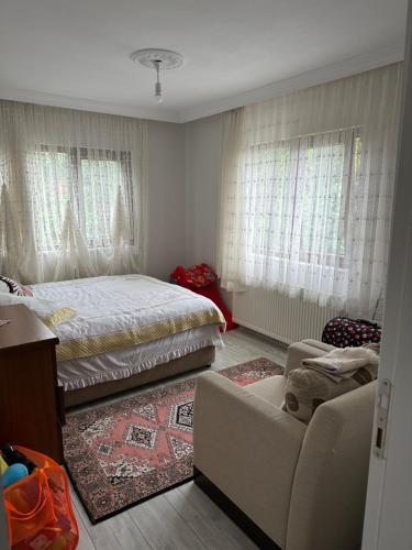 um quarto com uma cama, um sofá e janelas em Yomra / Trabzon em Yomra