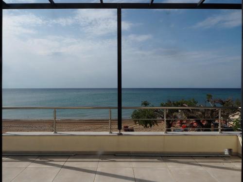 a room with a view of the beach and the ocean at Melissinos Beachfront Apartments in Kómi