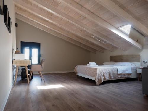 a bedroom with a bed and a desk in it at Melissinos Beachfront Apartments in Kómi