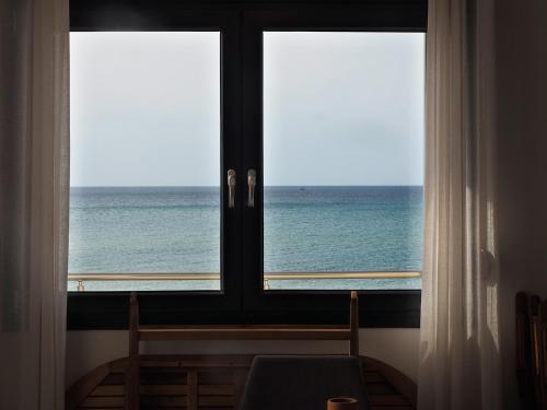 a window with a view of the ocean at Melissinos Beachfront Apartments in Kómi