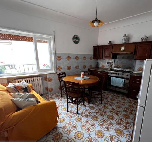 a living room with a table and a kitchen at Casa Dora in Anacapri