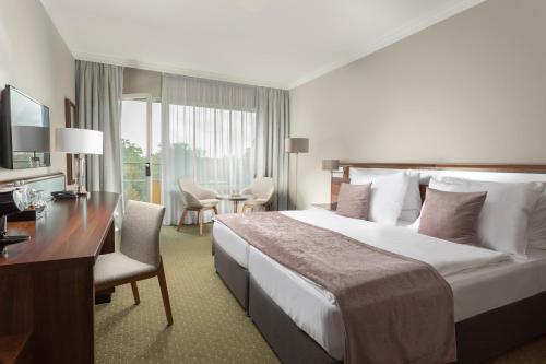 ラーズニェ・ビェロフラトにあるSpa Resort Tree of Lifeの大きなベッドとデスクが備わるホテルルームです。