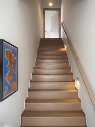 a staircase in a house with a painting on the wall at Melissinos Beachfront Apartments in Kómi