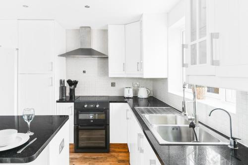 uma cozinha branca com um lavatório e um fogão em TravelNest Property em Bristol